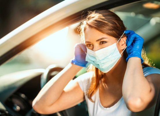 Mujer con mascarilla en un auto
